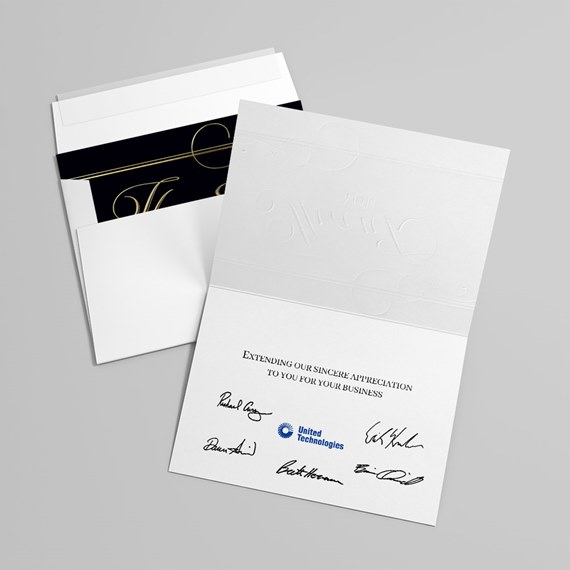 embossed card with black and gold design, printed text, and signatures
