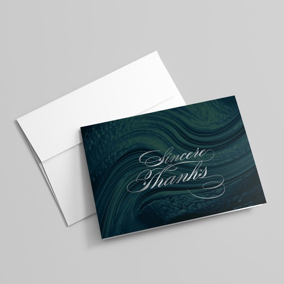 thank you card with swirling dark green design and white text, envelope
