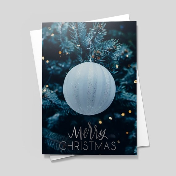 frosted ornament on pine tree with merry christmas text