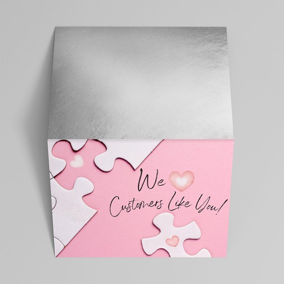 pink envelope with puzzle pieces and silver flap, text area