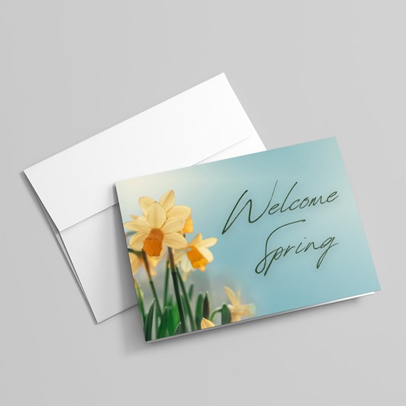 greeting card with daffodils and welcome spring text