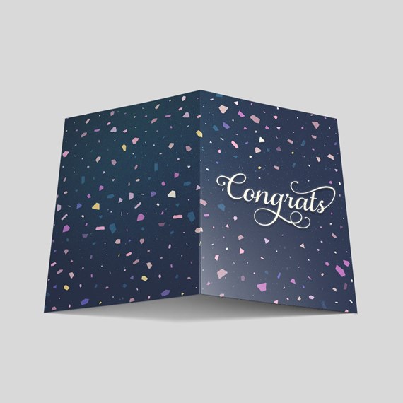 folded card with confetti design and script text