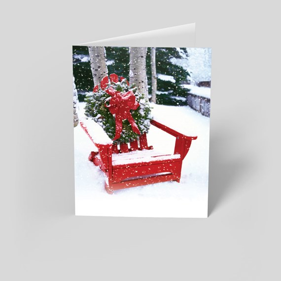 red sled with green wreath and red bow in snow